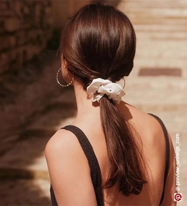 picture of a woman facing the wall with a pony and scrunchie
