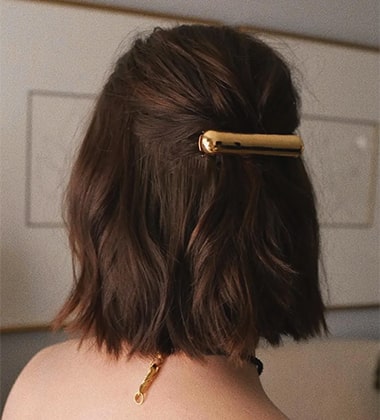 the back shot of a woman with golden buckle in her hair