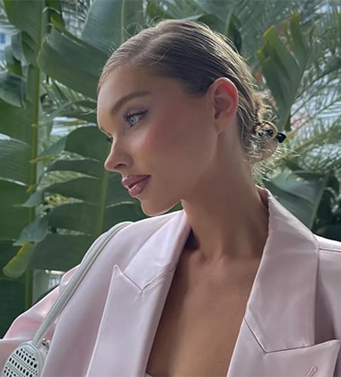 woman wearing a beige blazer and standing in the balcony
