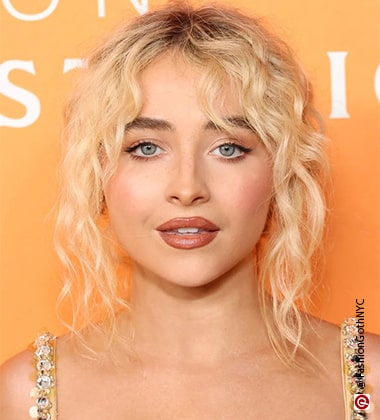 woman with blonde hair with a orange background